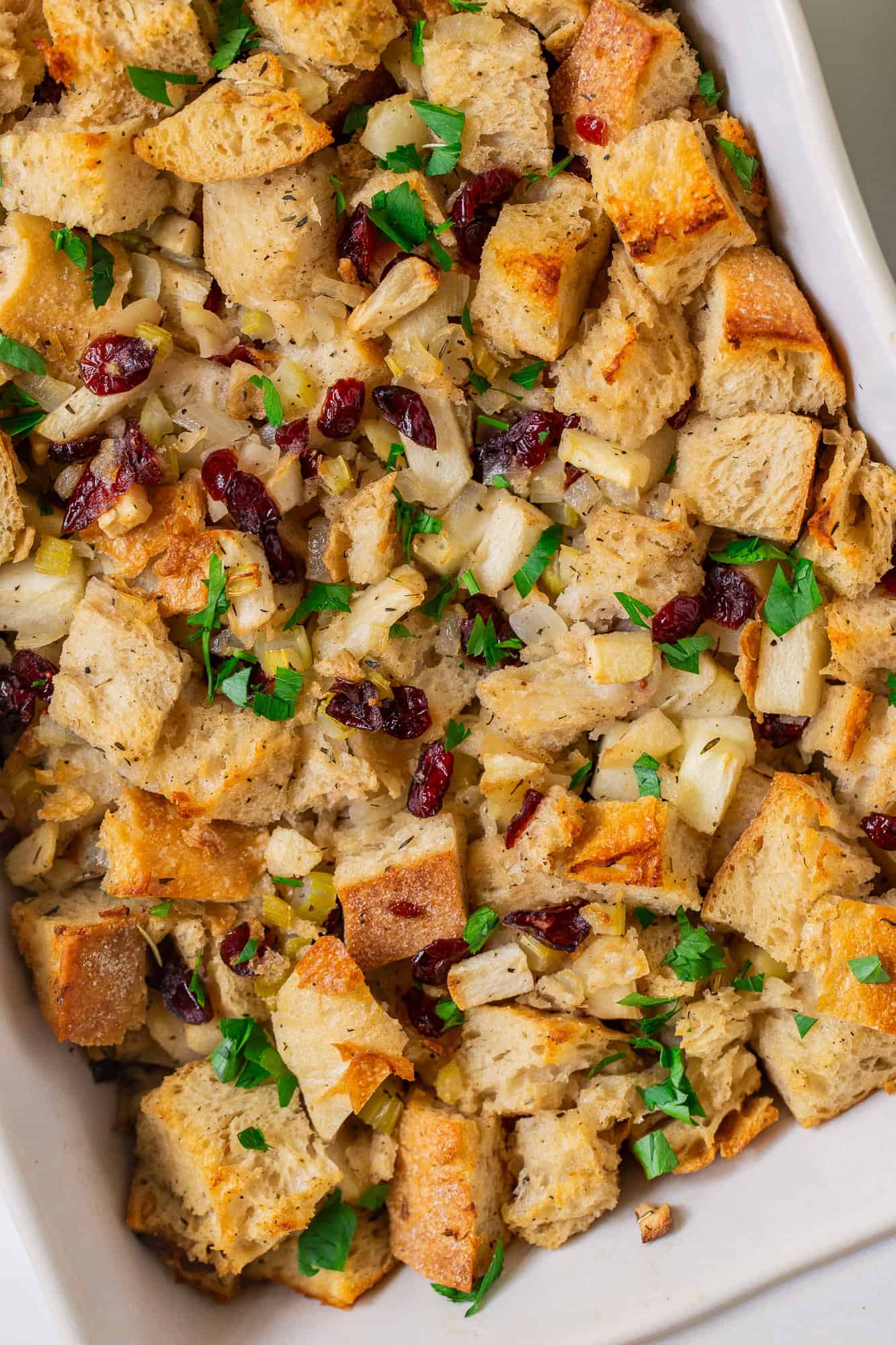 Close up of stuffing with apples and cranberries and sourdough bread.