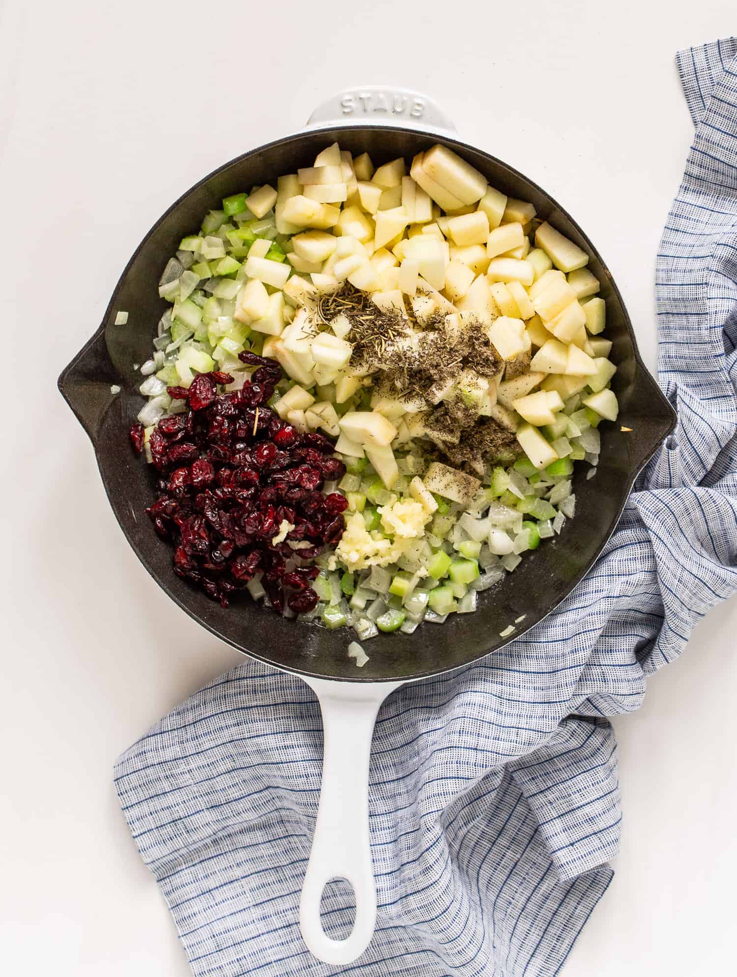 Apples, cranberries, herbs, added to pan and not yet mixed in.