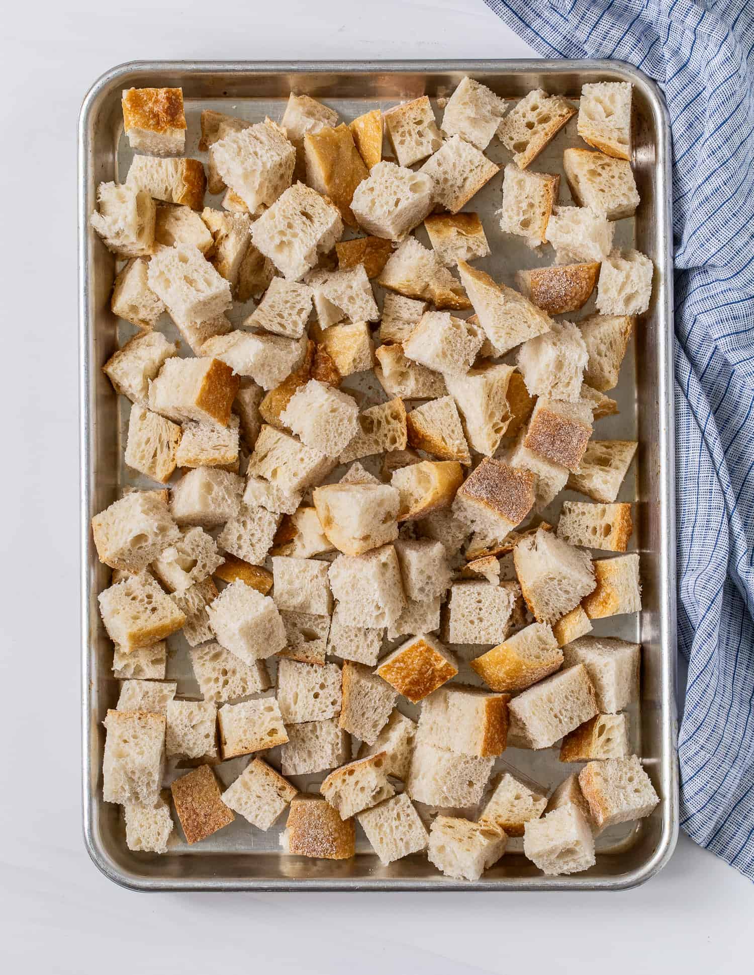 Bread cubes on a sheet pan.