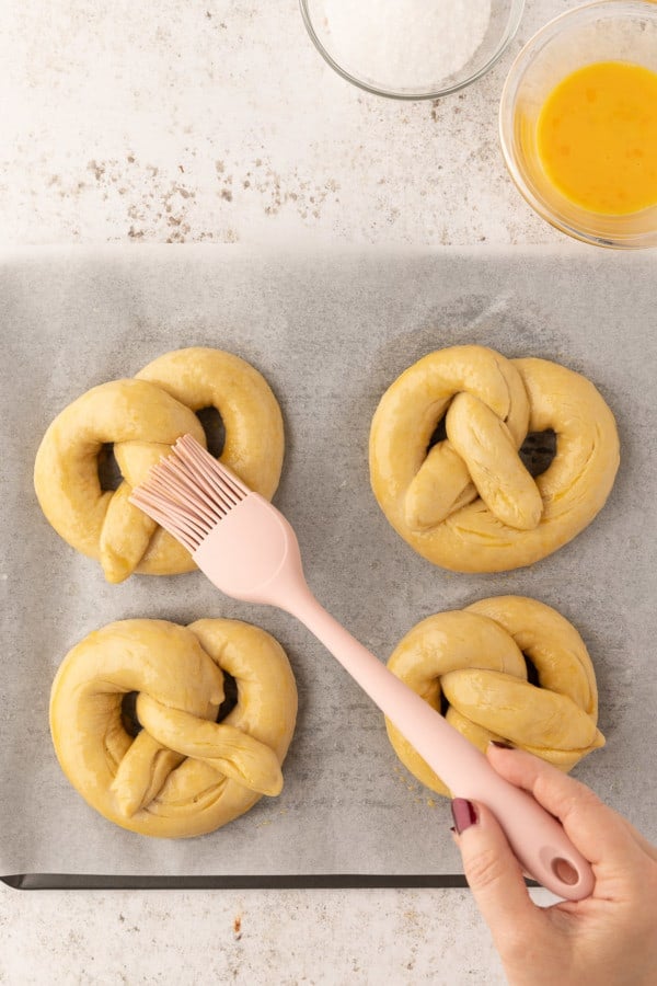 Pretzels being brushed with egg.