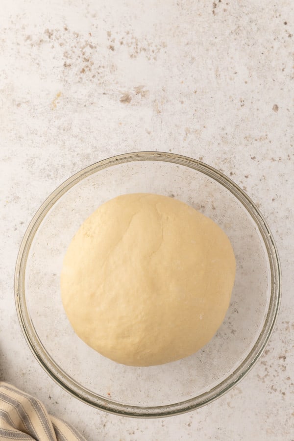 Pretzel dough in glass mixing bowl, after rising.