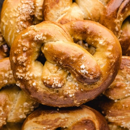 Homemade soft pretzel placed on top of additional pretzels.