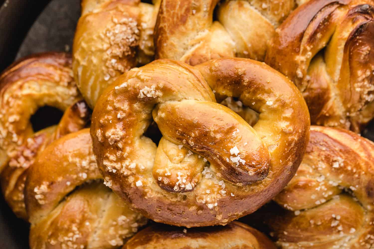 Homemade soft pretzel sitting on a pile of others.