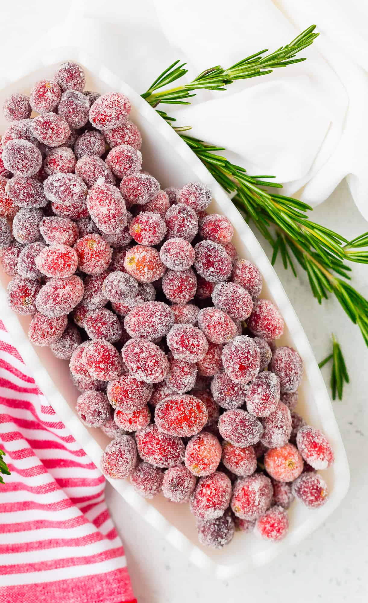 Overhead view of sugared cranberries in a bowl.