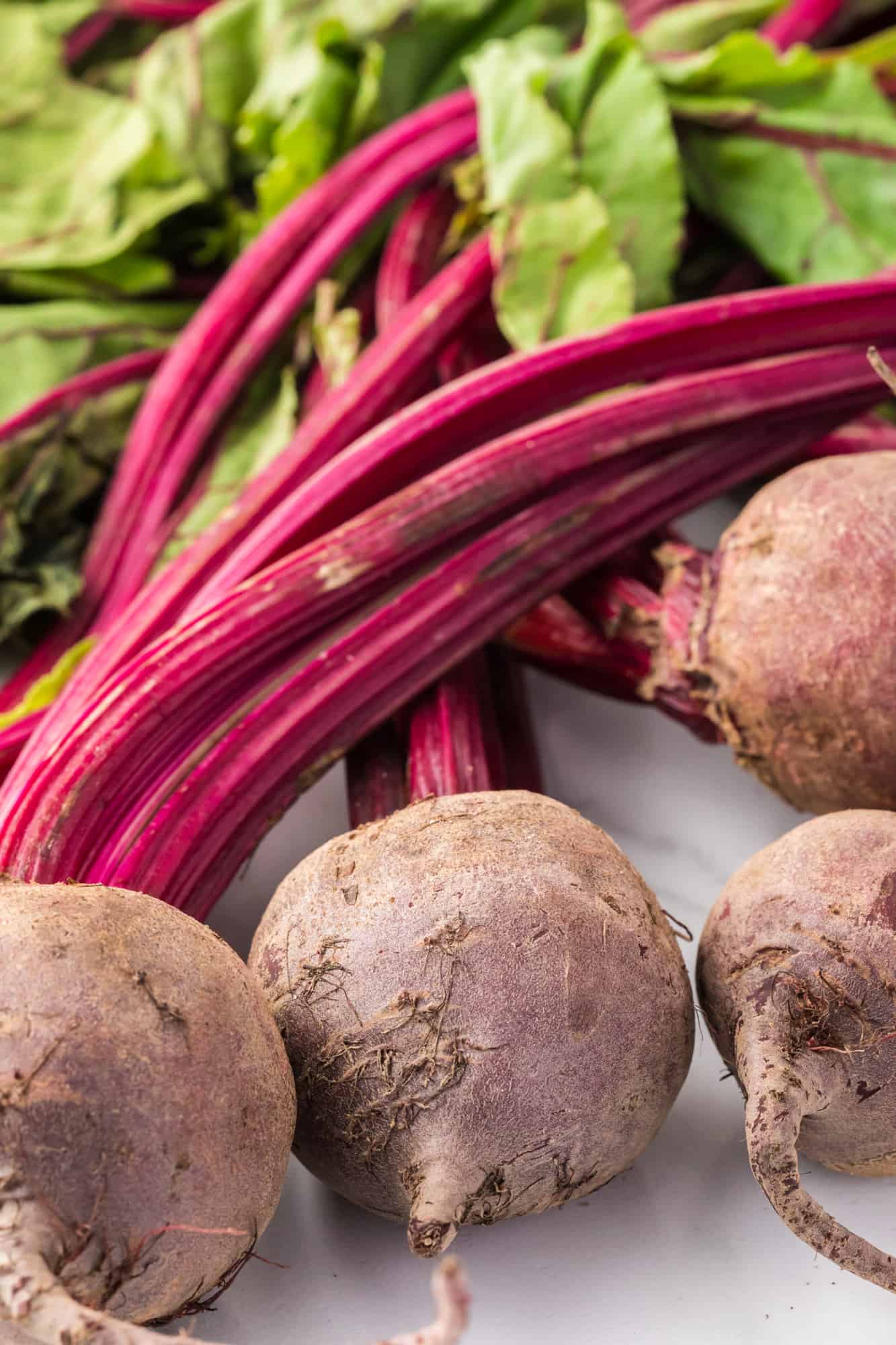 Uncooked, unpeeled beets, with the greens still attached.