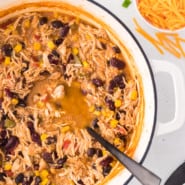 Overhead view of a large pot of chicken taco soup with a serving spoon.
