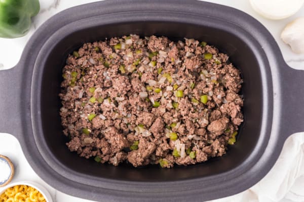 Overhead view of browned ground beef in the crockpot.