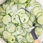German cucumber salad, with a spoon scooping some out.