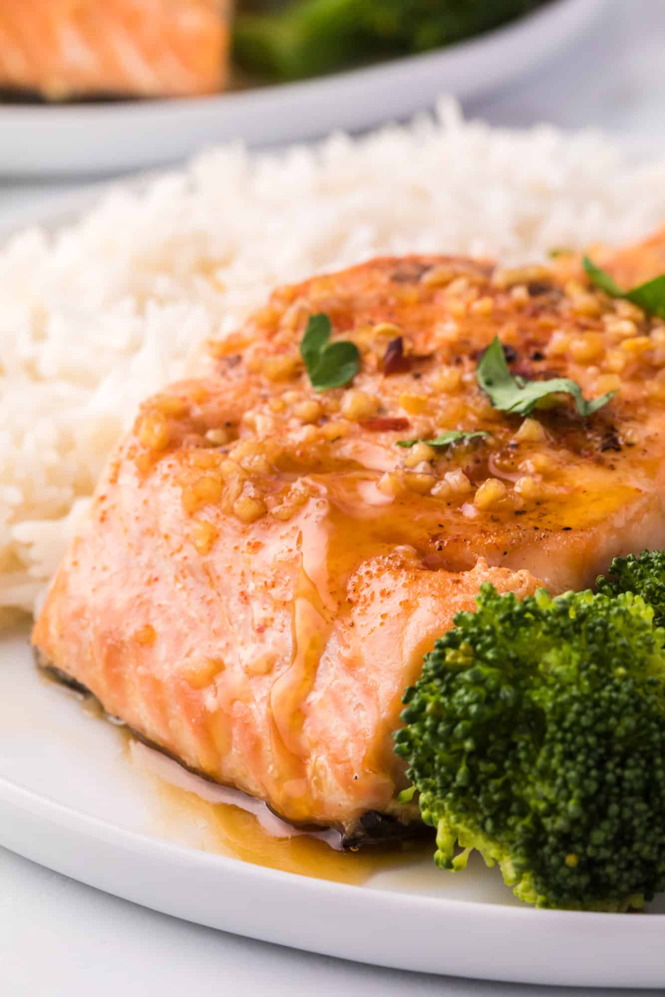 Honey garlic salmon on a plate with rice and broccoli.