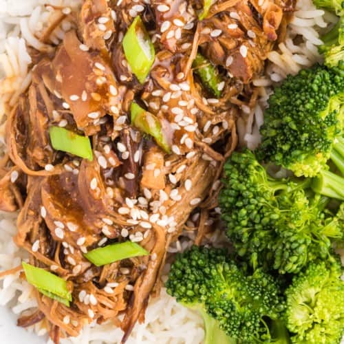 Close up of instant pot teriyaki chicken served next to broccoli in a bowl of white rice.