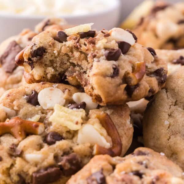 Close up of a pile of kitchen sink cookies with a bite missing from the top cookie.