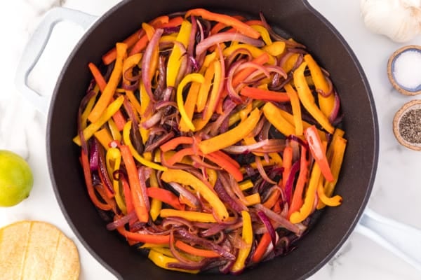 Overhead view of steak fajitas in a skillet.