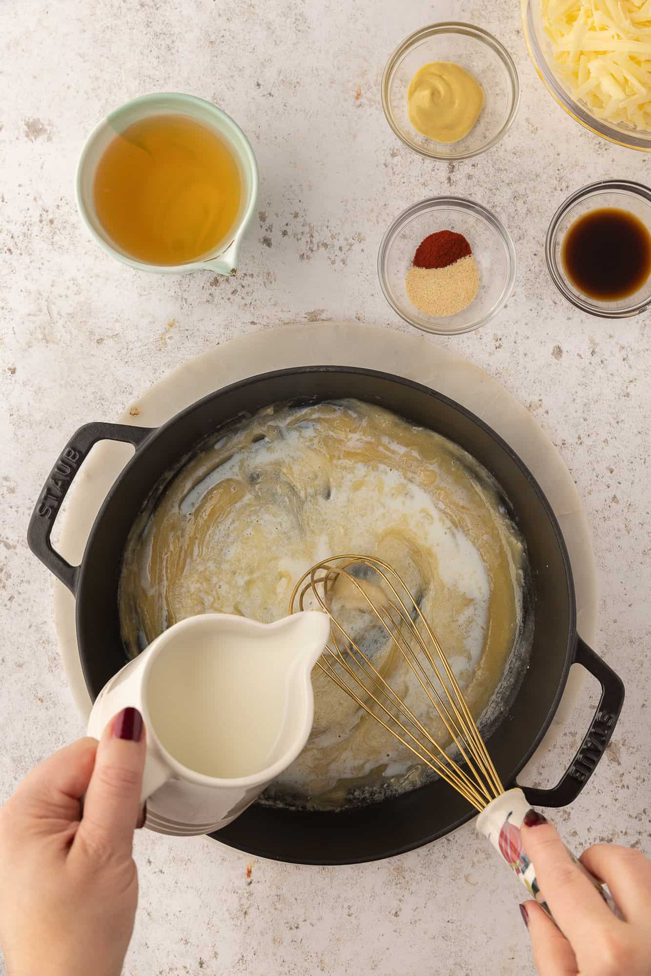 Milk being poured into roux.