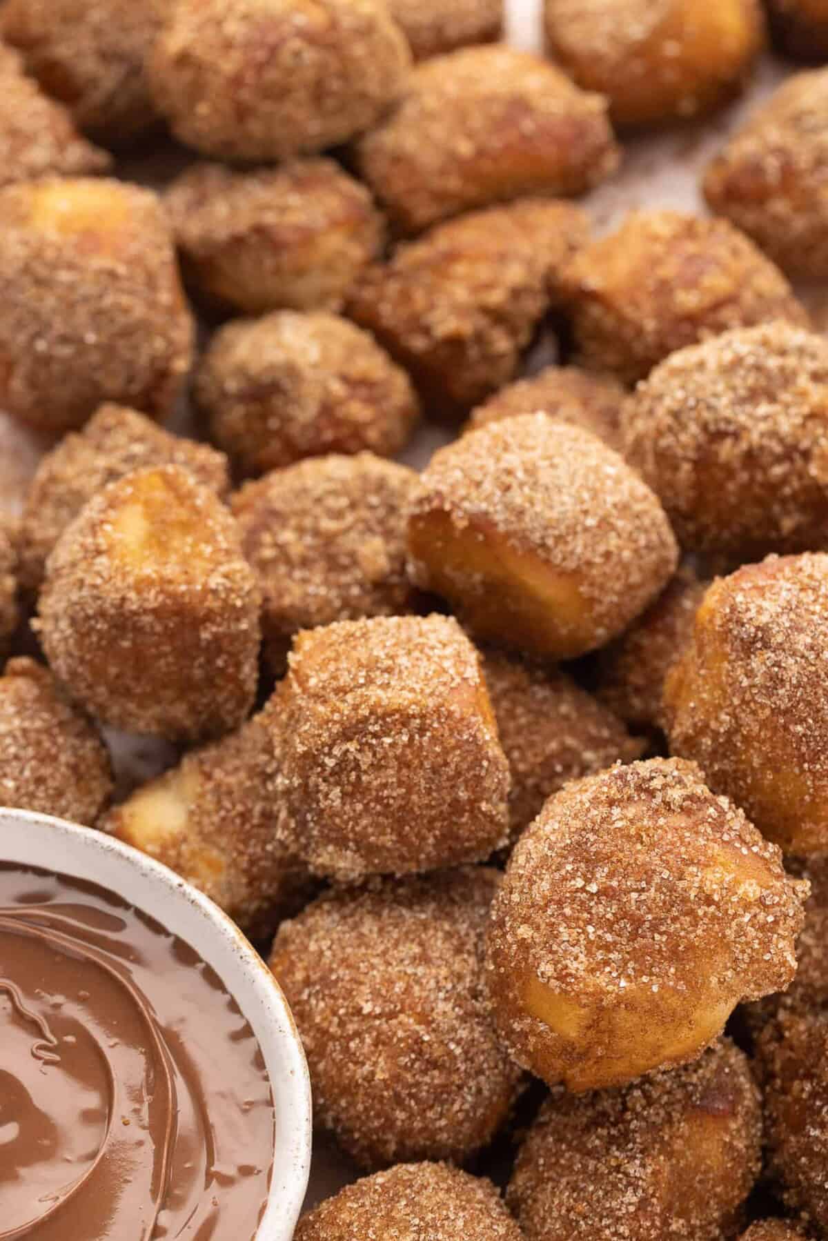 Close up of cinnamon sugar pretzel bites next to a small bowl of nutella for dipping.