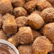 Close up of cinnamon sugar pretzel bites next to a small bowl of nutella for dipping.