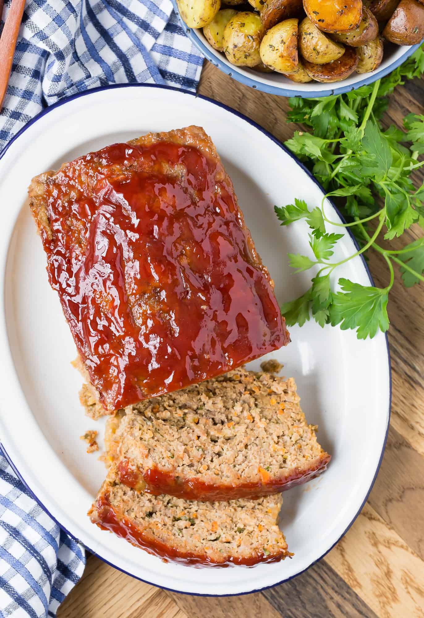 Overhead view of partially sliced meatloaf with tomato glaze.