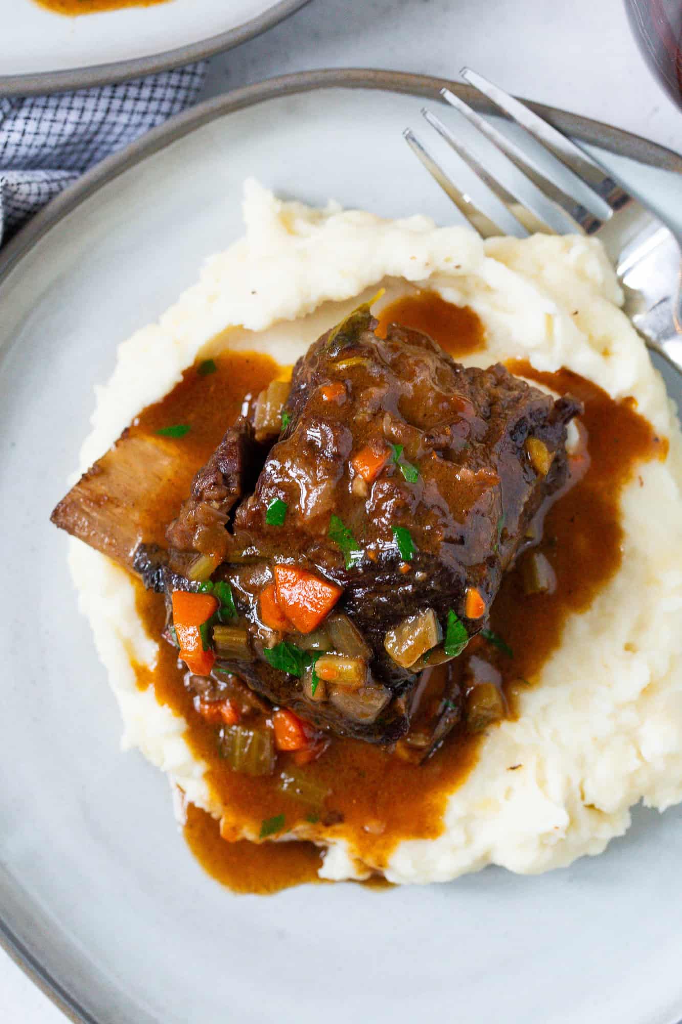 Overhead view of braised short rib on top of mashed potatoes.