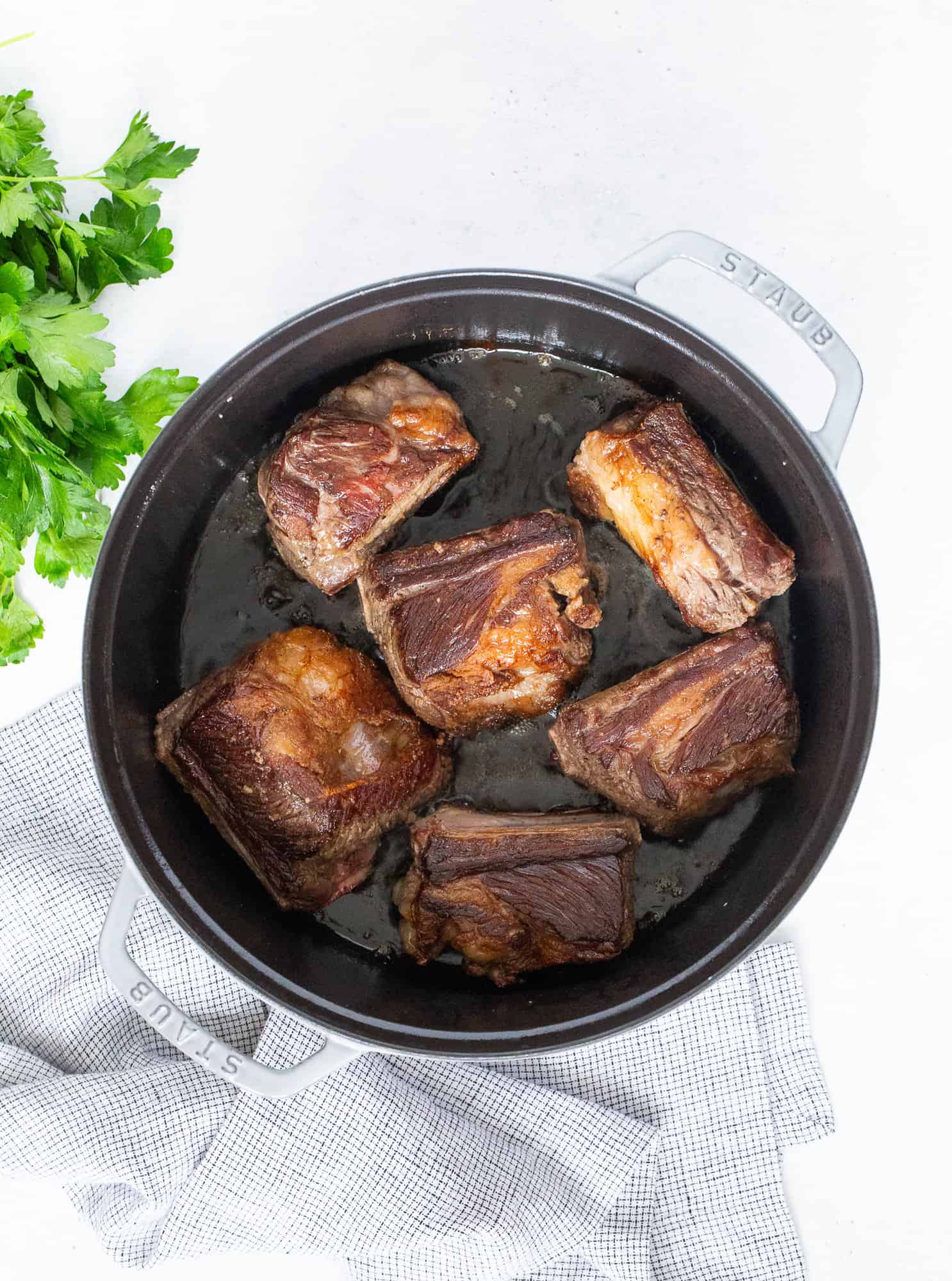 Browned ribs in a Dutch oven pan.