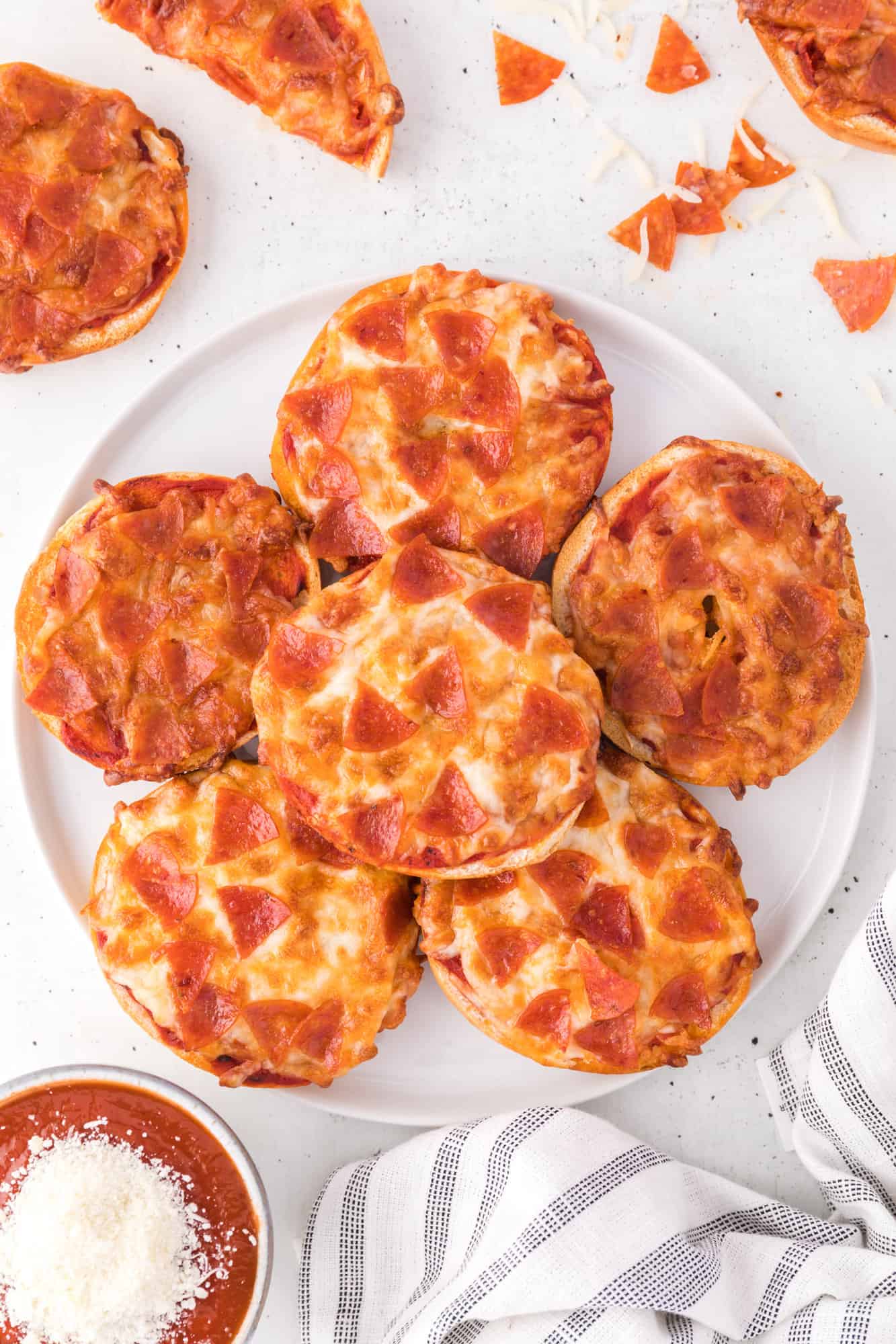 Air fryer bagel bites piled up on a large white plate.