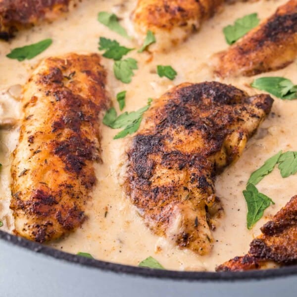 Cream of mushroom chicken in a black skillet.