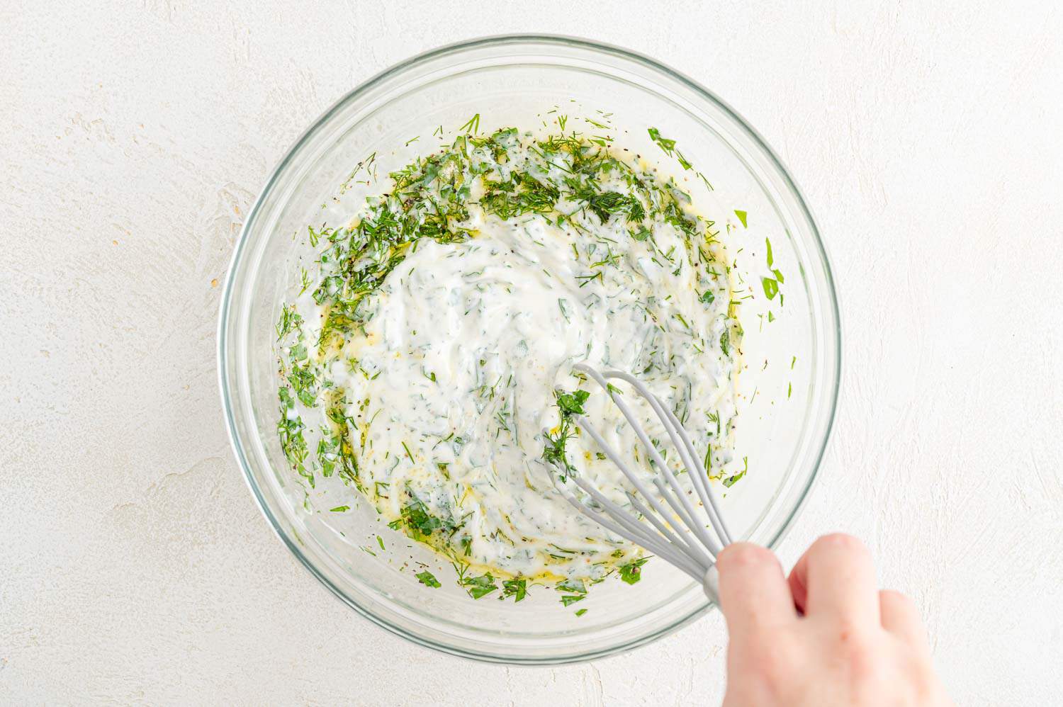 Dressing ingredients being mixed together with a whisk.