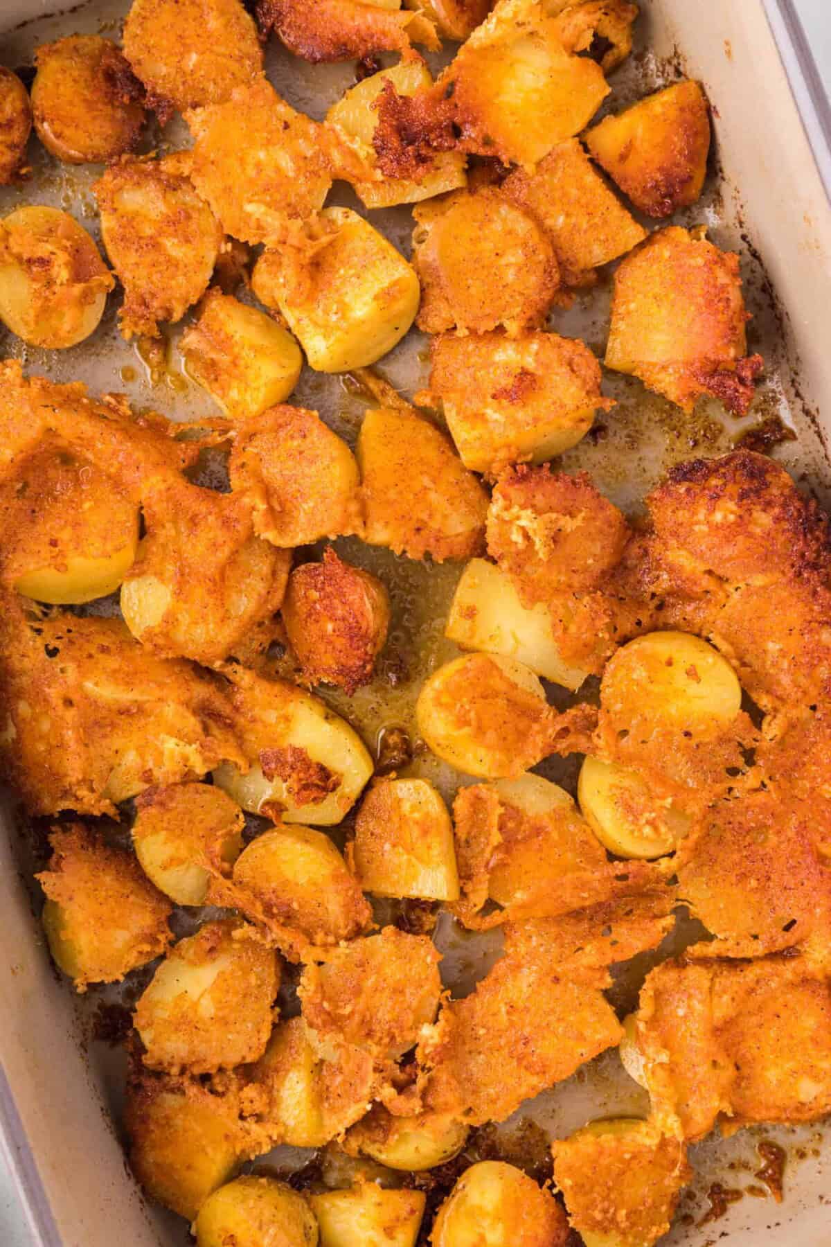 Overhead view of parmesan potatoes in a baking dish.