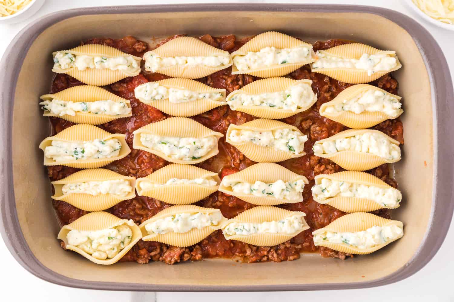 Stuffed shells added to layer of meat sauce.