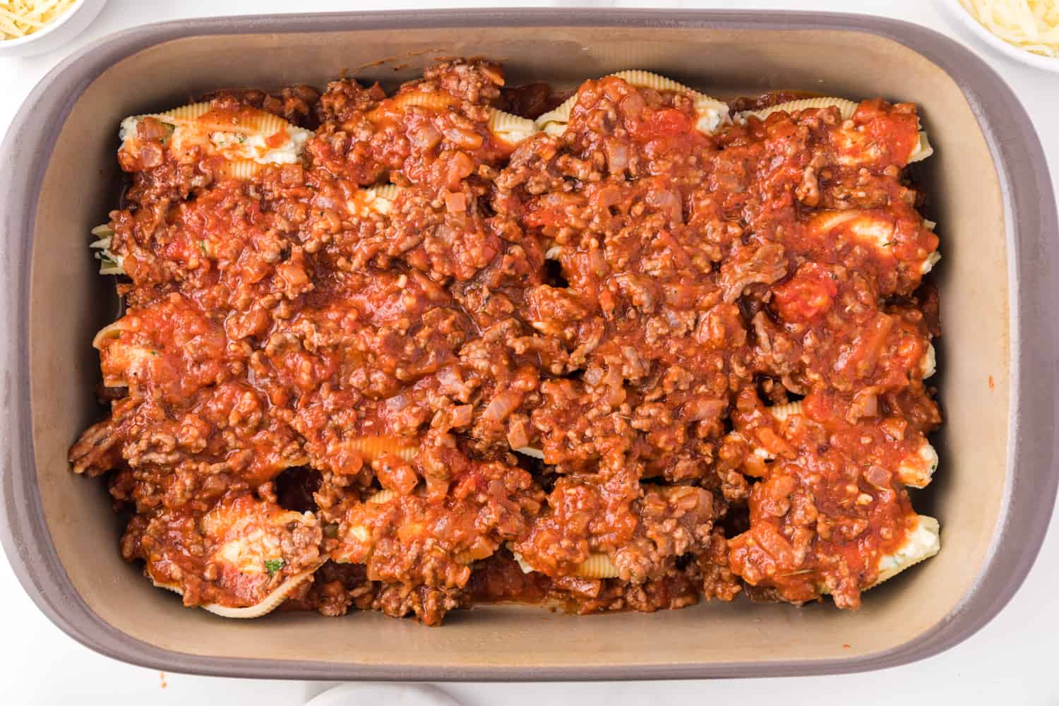 Meat sauce added on top of stuffed shells.