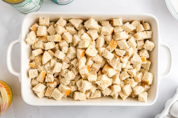 Bread cubes added to a casserole dish.