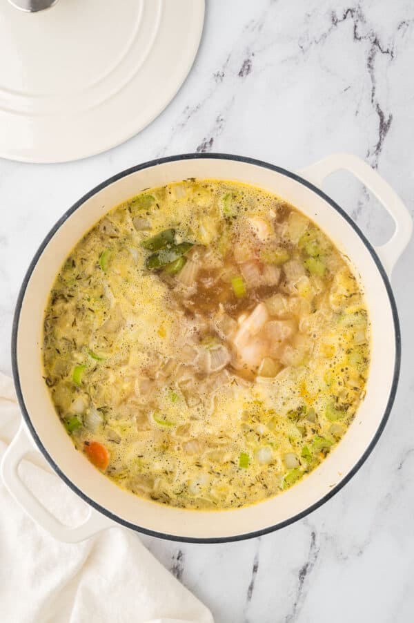 Chicken soup ingredients simmering in a large pot.