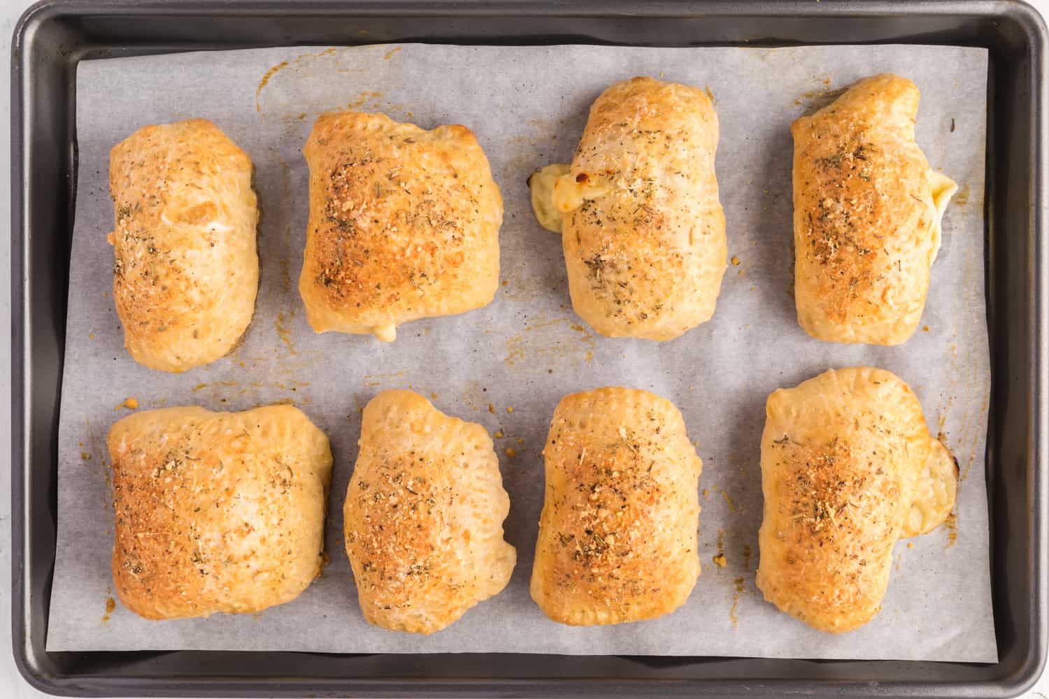 Baked homemade hot pockets on a sheet pan.