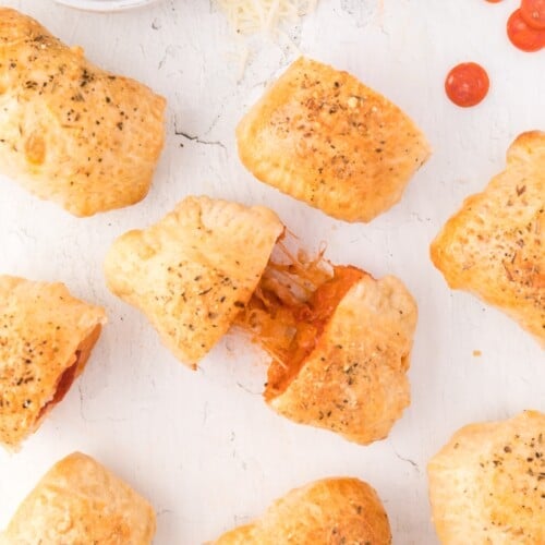 Overhead view of homemade hot pockets, one being pulled apart to show filling.