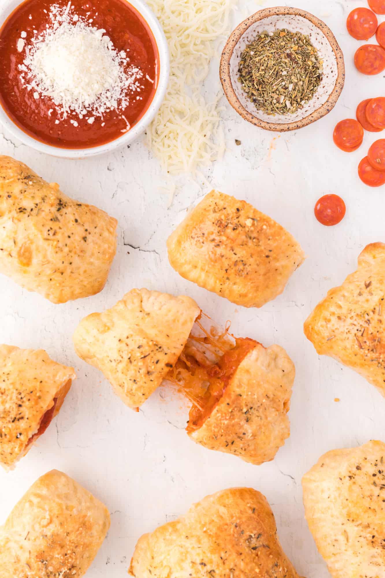 Overhead view of homemade hot pockets, one being pulled apart to show filling.