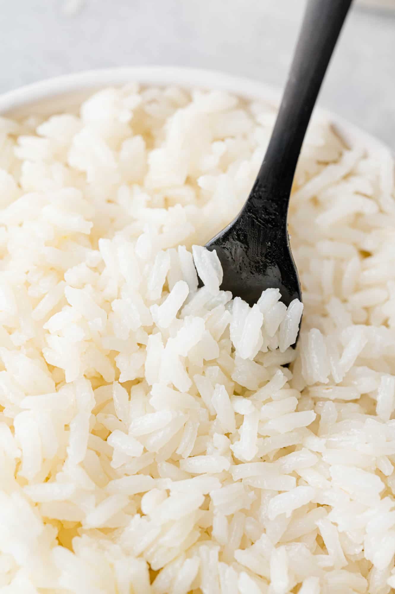 Fluffy jasmine rice in a bowl and on a black fork.