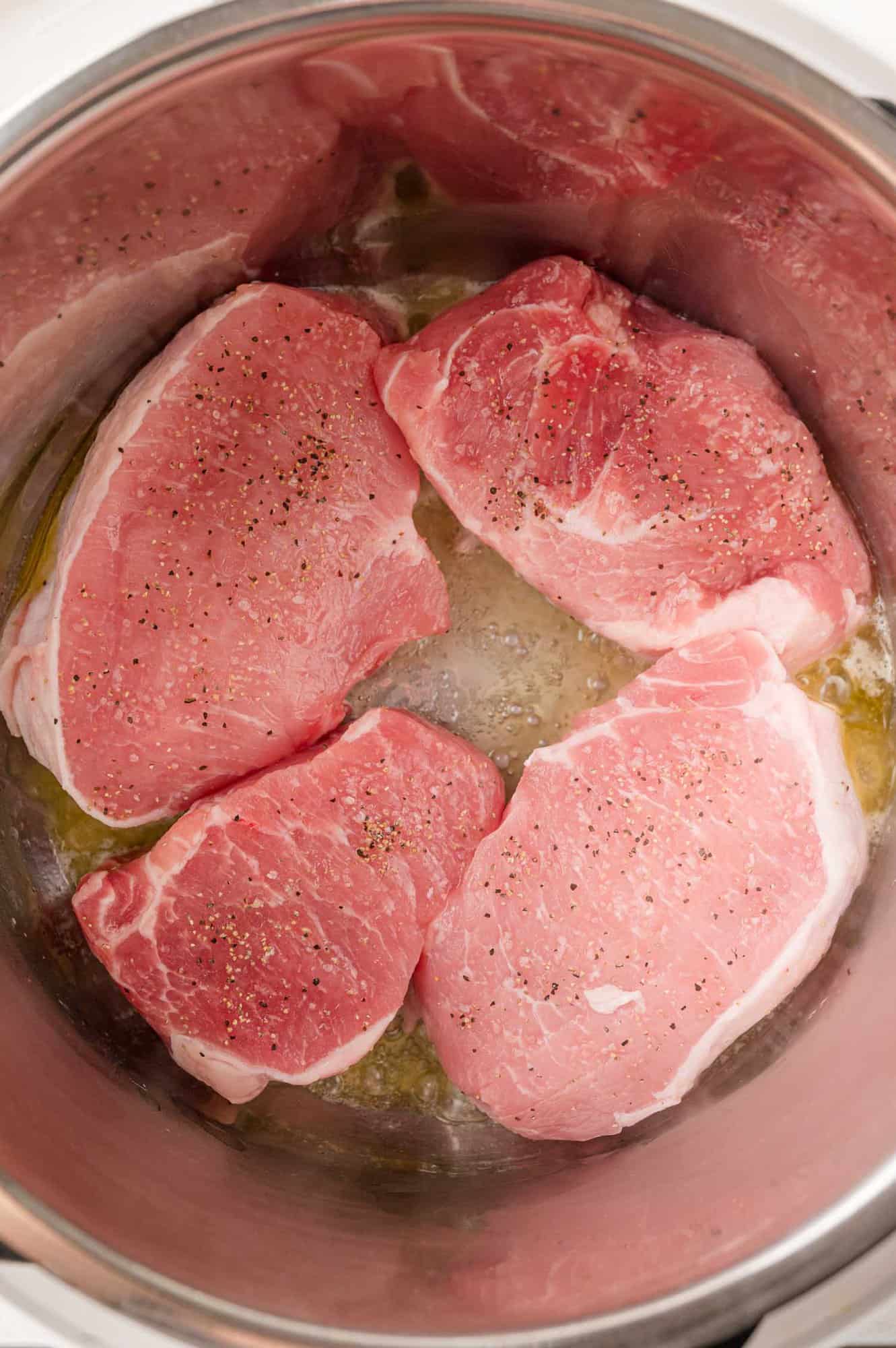 Pork chops in Instant pot, being seared.