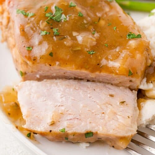 Instant pot pork chop, cut to show inside, topped with gravy.