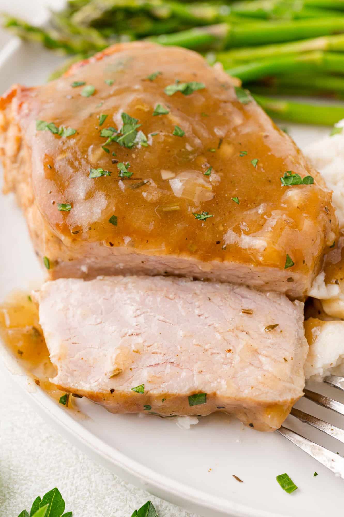 Instant pot pork chop, cut to show inside, topped with gravy.