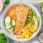 Overhead view of salmon bowl with cucumber, mango, edamame, and more.