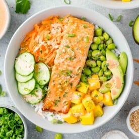Overhead view of salmon bowl with cucumber, mango, edamame, and more.