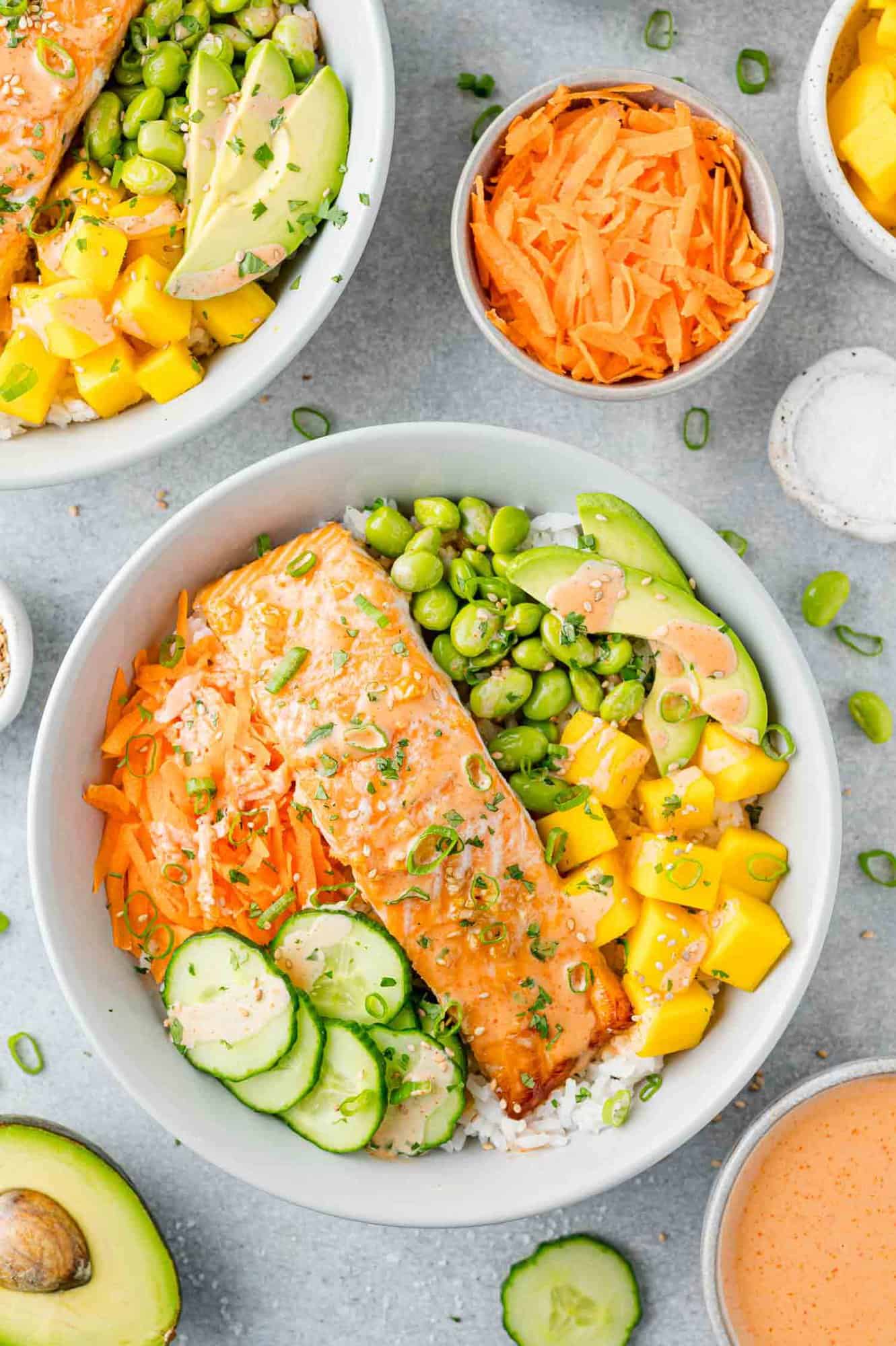 Salmon bowl with carrots, cucumber, mango, edamame, and sprinkled with sesame and cilantro.