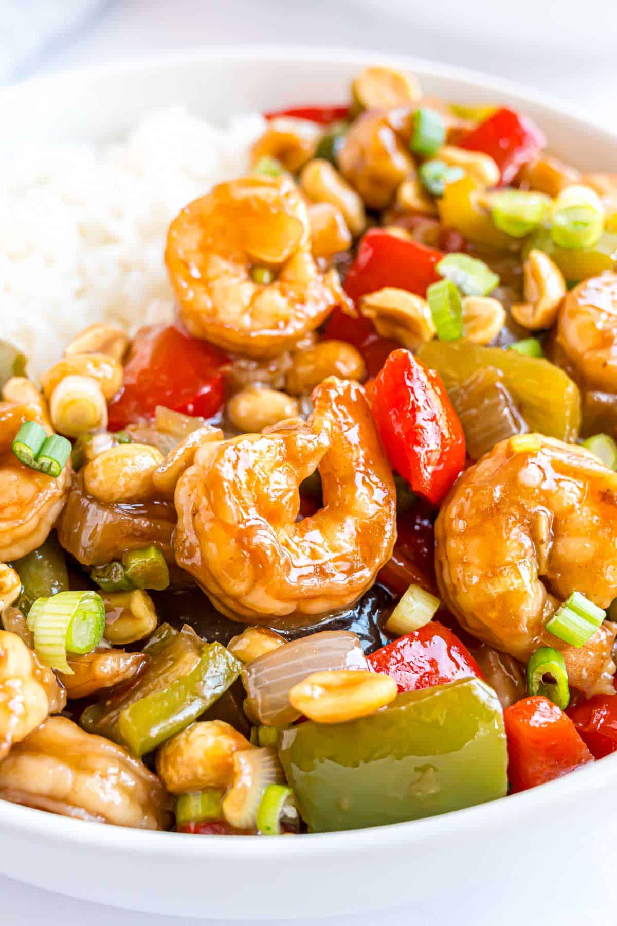 Kung Pao shrimp, shown with rice, garnished with green onions.