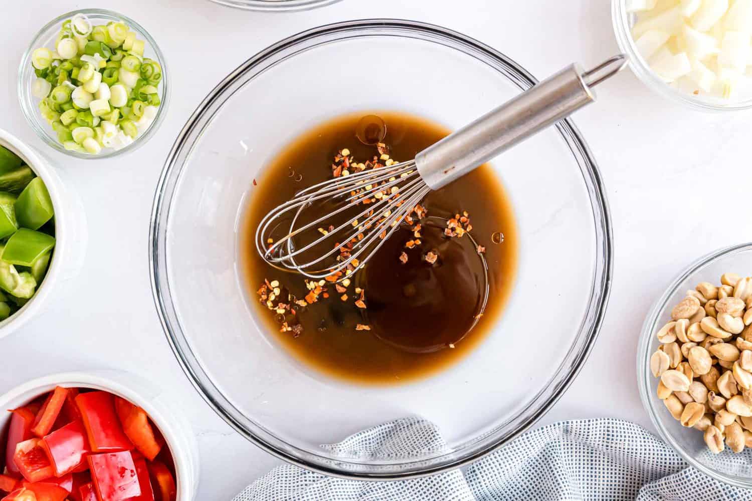 Sauce ingredients in a small glass bowl with a whisk.