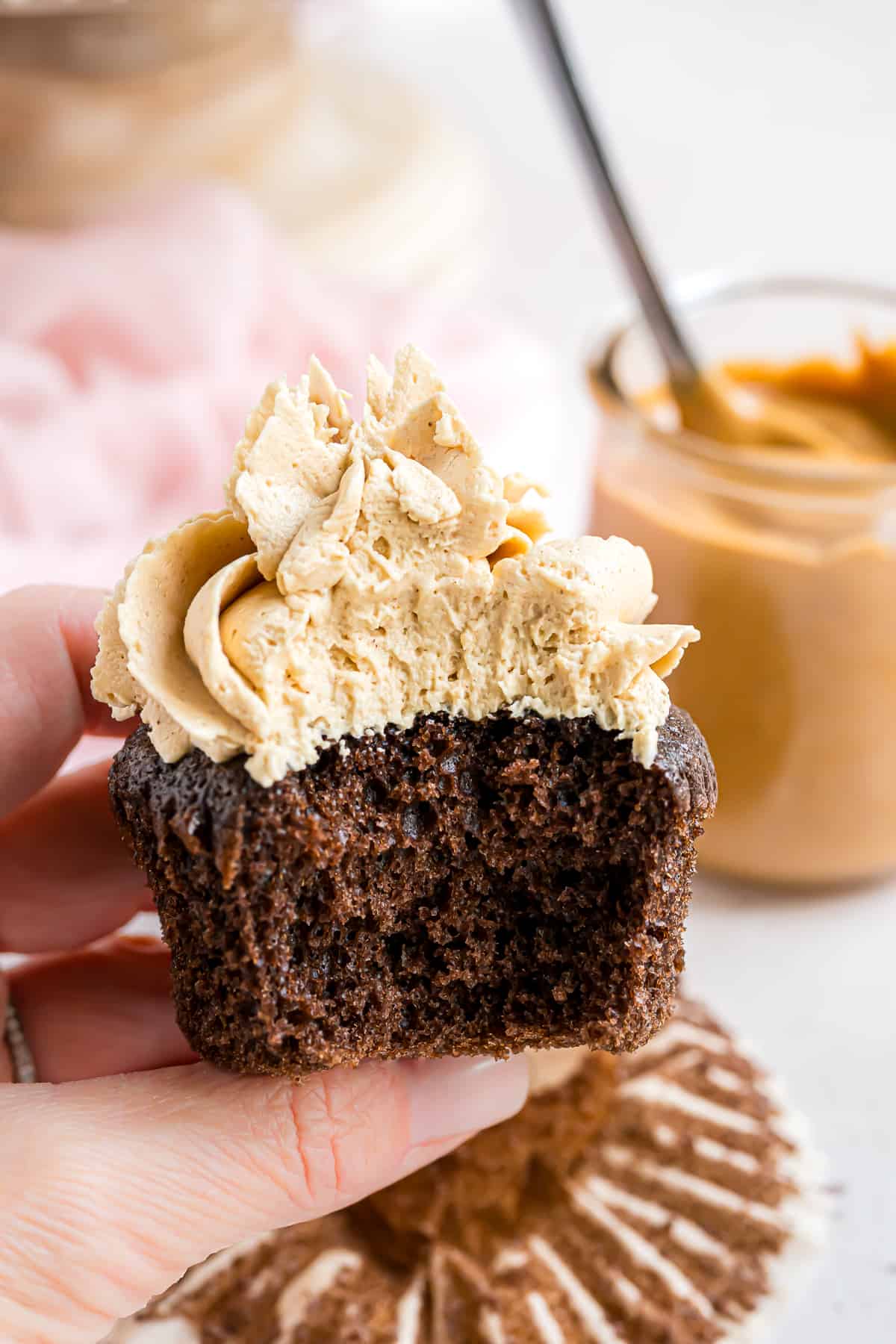 Chocolate cupcake with peanut butter frosting, large bite removed.