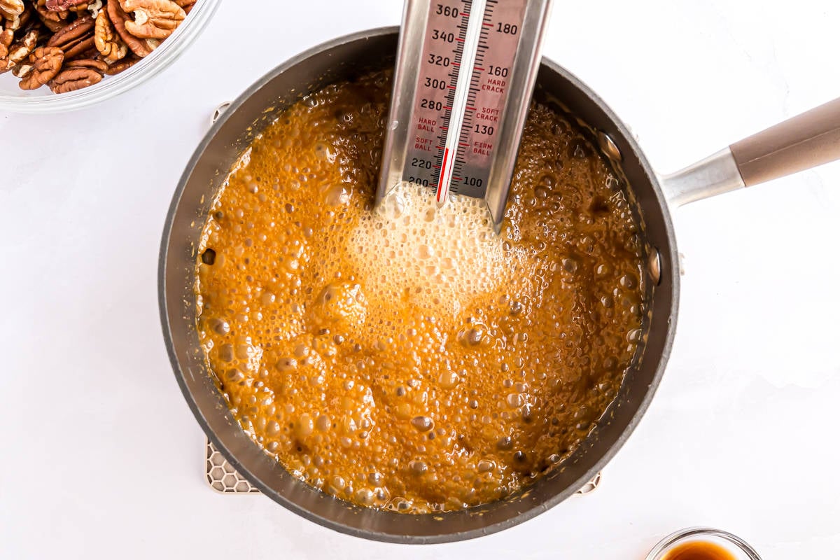 Candy mixture boiling, with a candy thermometer inserted.