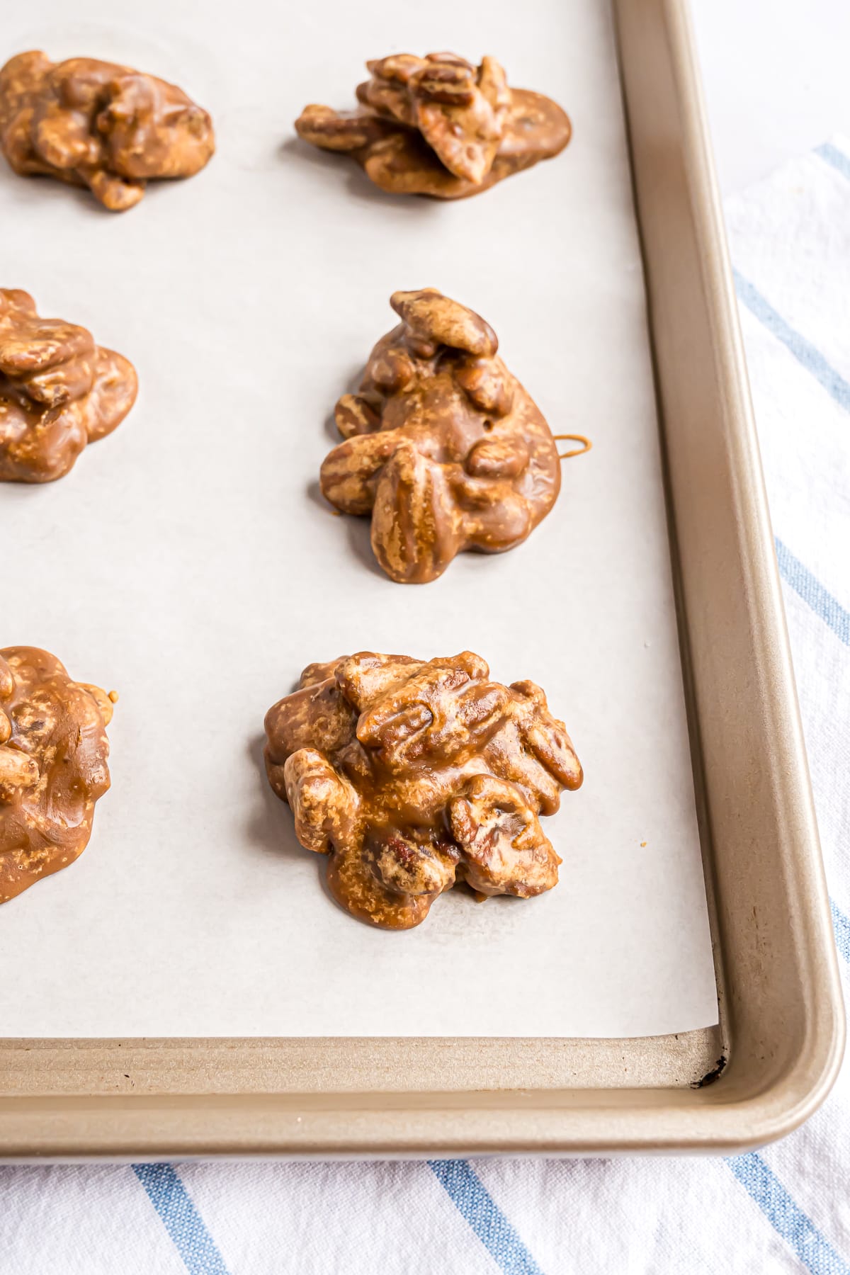 Pralines cooling on a parchment paper lined sheet.