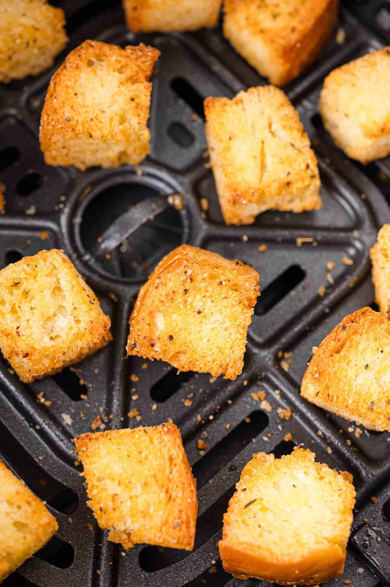 Croutons in a black air fryer.