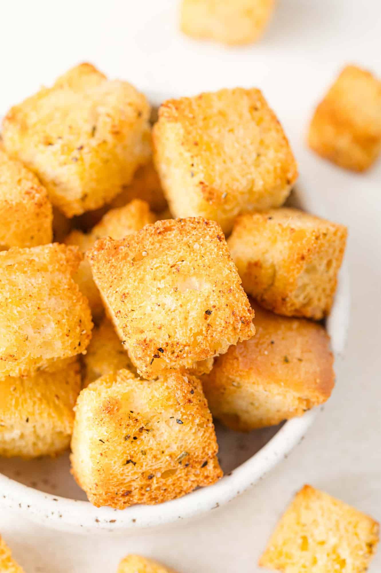 Air fryer croutons in a small white bowl.