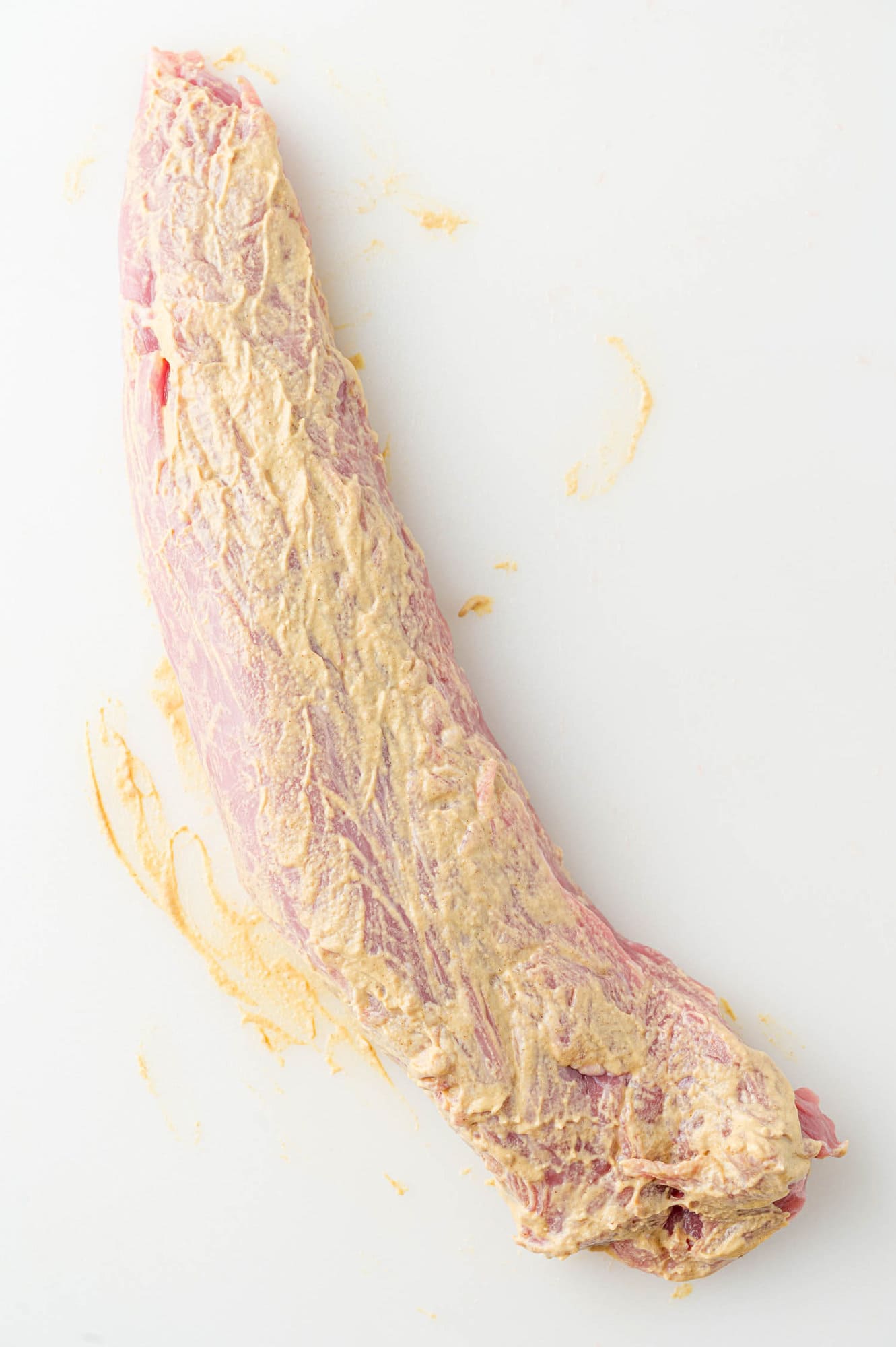 Pork tenderloin rubbed with dijon mustard.