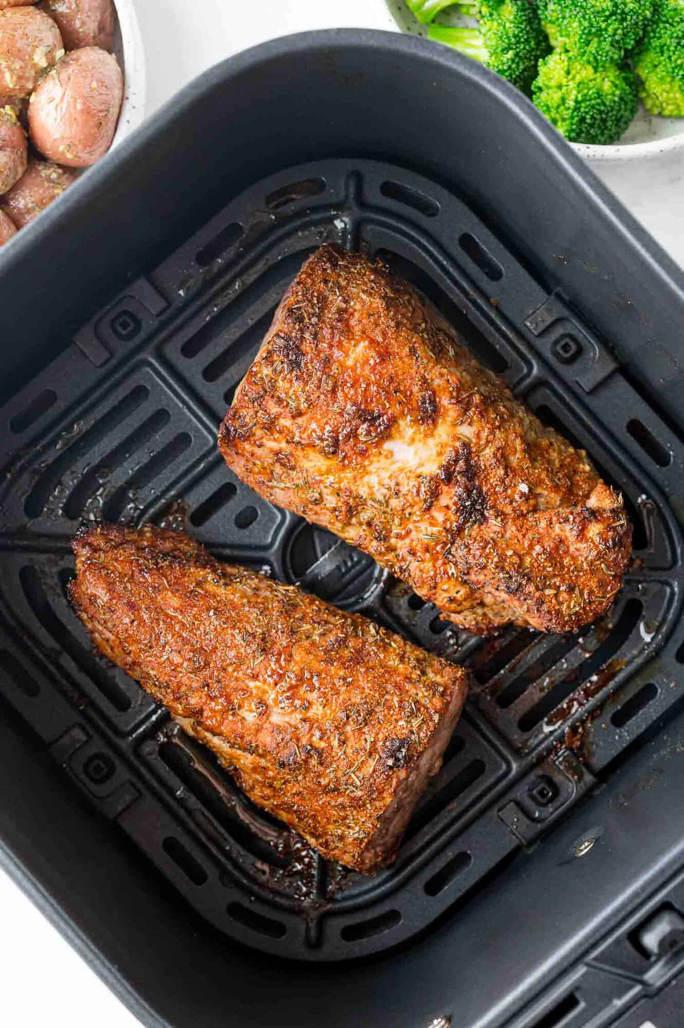 Pork tenderloin, cut in two pieces, in an air fryer.