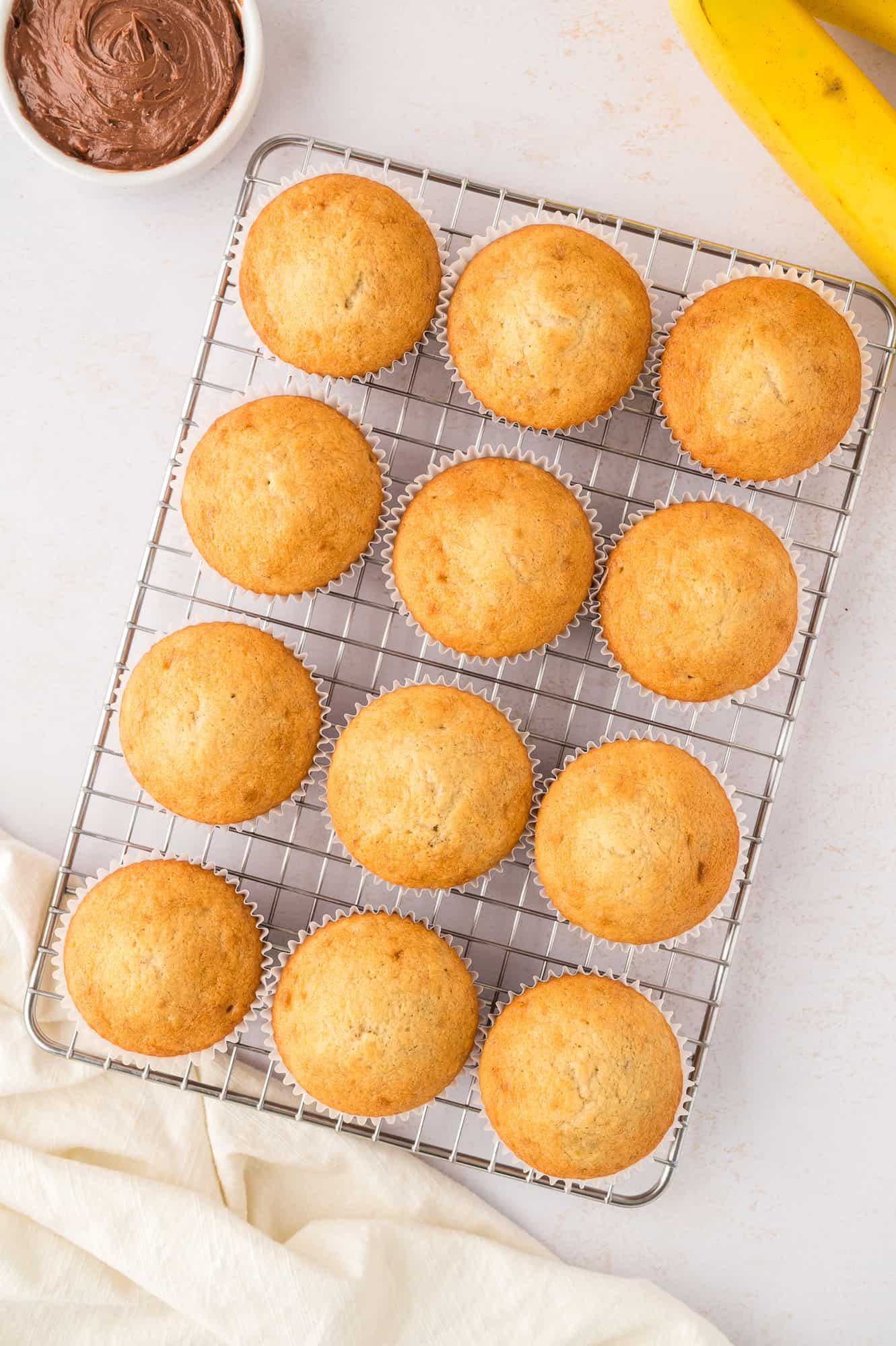 Unfrosted cupcakes on cooling rack.